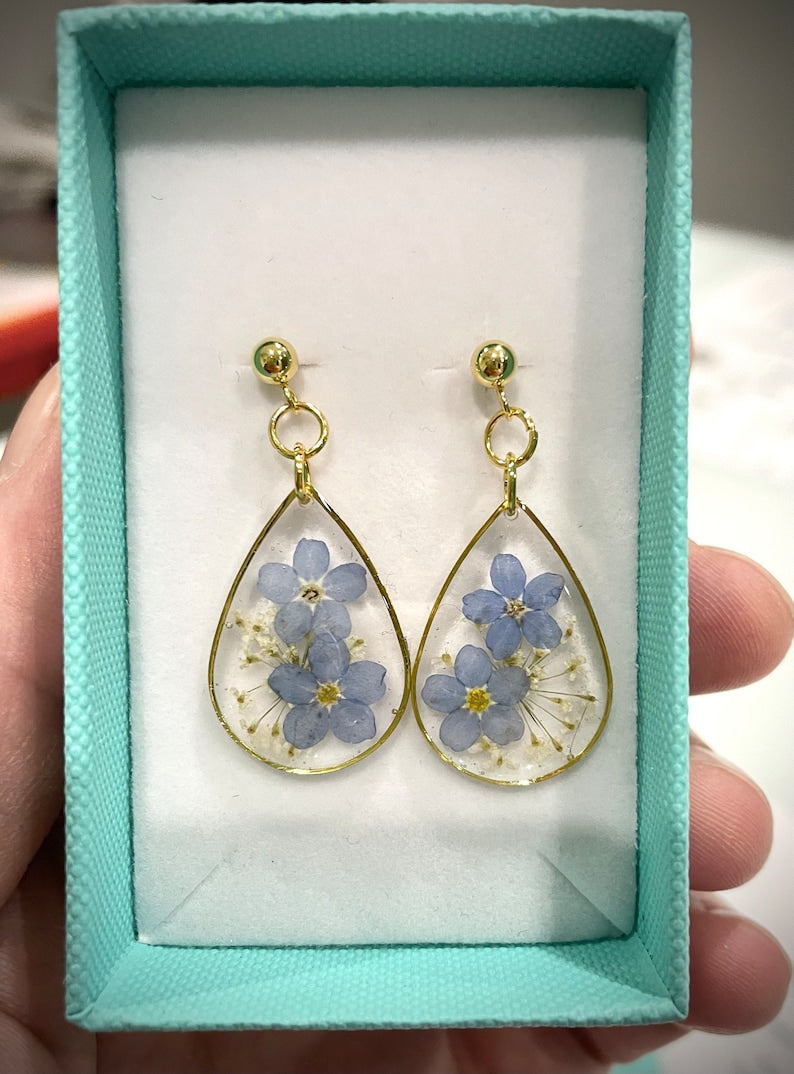 Drop resin earrings with forget-me-not flowers. Forget-me-not earrings and white lace. Real flowers do not forget me.